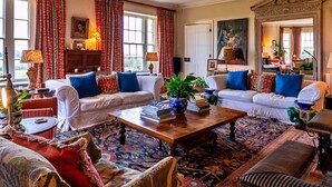 Ein traditionell eingerichtetes Wohnzimmer mit zwei Sofas, einem Couchtisch und einem gemusterten Teppich.