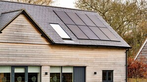 A modern house with a sloped roof, large windows, and a visible solar panel installation. - Beautiful  villa for 8 people with WIFI, TV and pets allowed (Alcester)