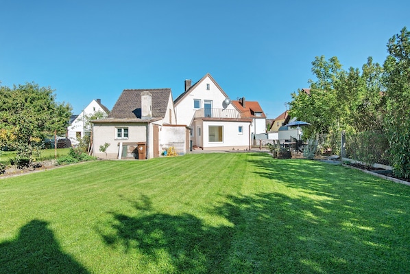 A residential property with a well-maintained lawn, a house with a sloped roof, and a satellite dish.