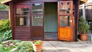 A wooden cabin with a large sliding glass door, a small porch, and a potted plant in front. - Wonderful  villa for 5 people with WIFI, TV and pets allowed (Burnham-on-sea)
