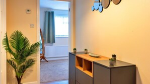 A modern apartment with a wooden floor, a potted plant, a built-in desk, and a wall-mounted mirror. - Wonderful  villa for 5 people with WIFI, TV and pets allowed (Burnham-on-sea)