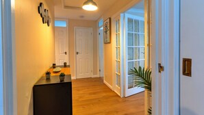 A hallway with wooden flooring, white doors, and a ceiling light fixture. - Wonderful  villa for 5 people with WIFI, TV and pets allowed (Burnham-on-sea)