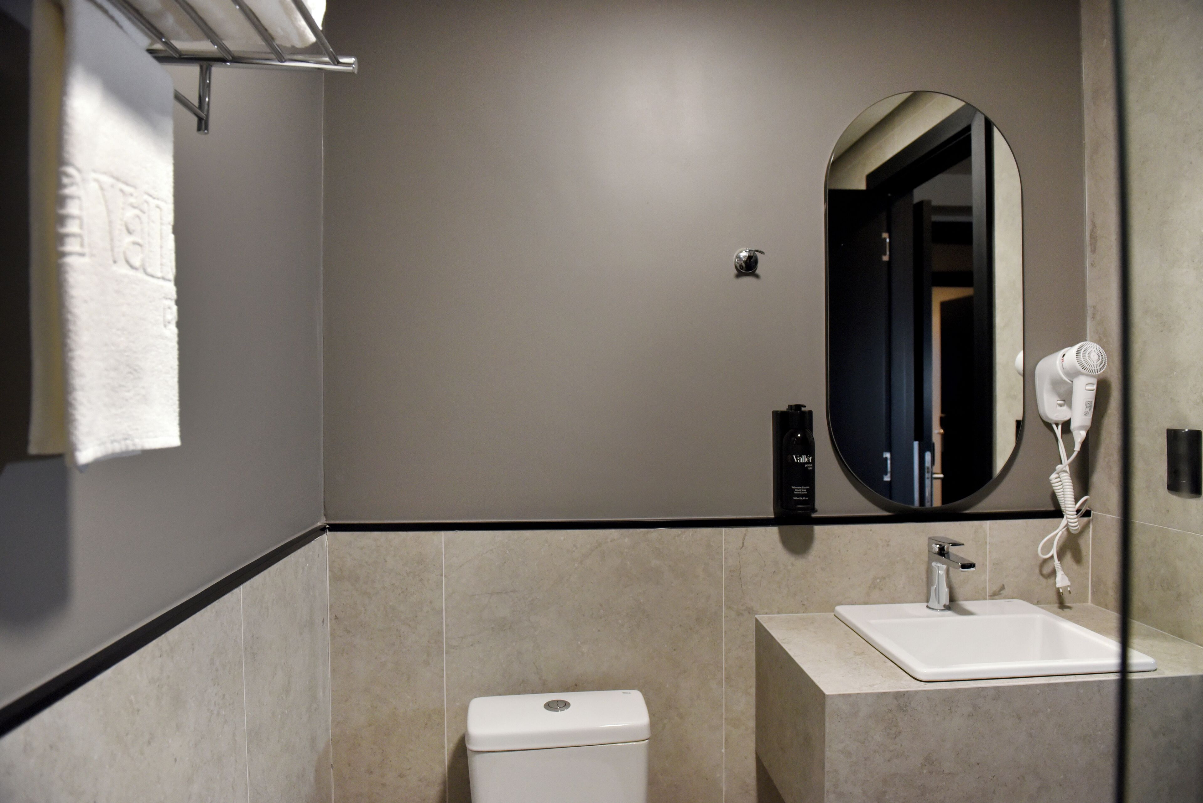A modern bathroom with a toilet, sink, and a mirror.