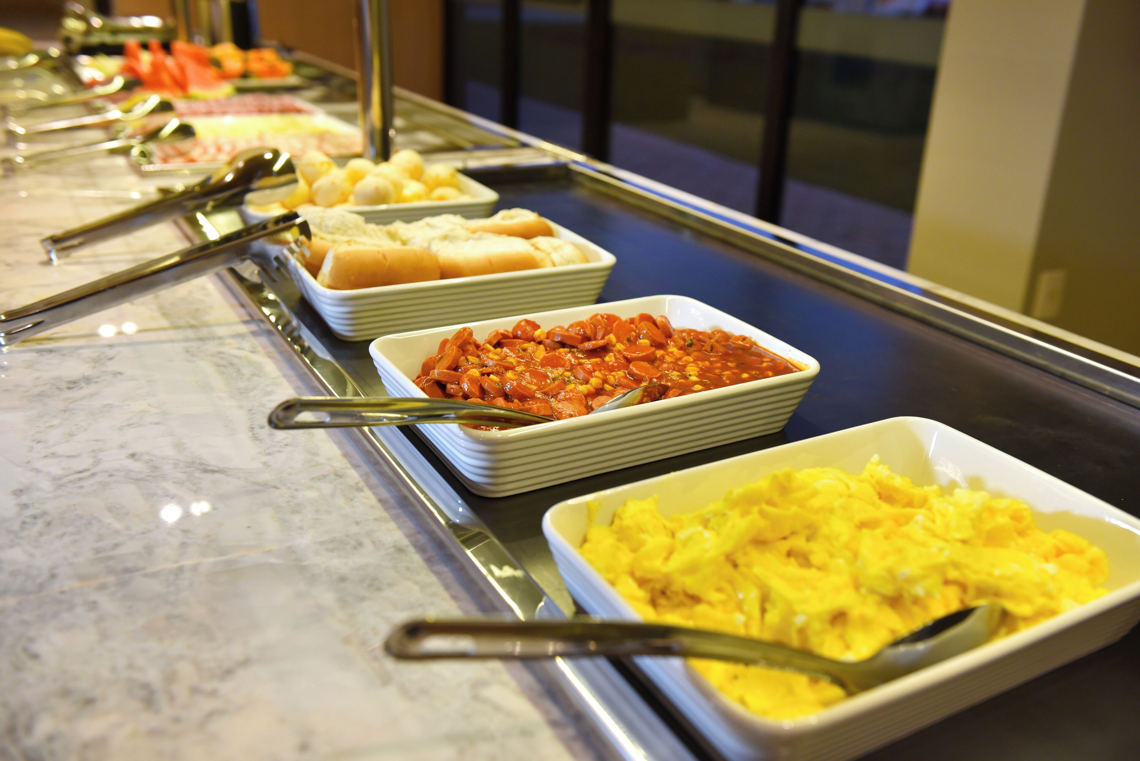 Ein Buffet mit verschiedenen Speisen, darunter Pasta, Brot und eine Auflaufform.