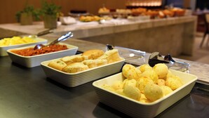 A buffet with various food items including bread, cheese, and other dishes. - Vallér Parque Hotel Executive (Lajeado)
