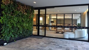 A modern interior with a green wall, large windows, and contemporary furniture. - Vallér Parque Hotel Executive (Lajeado)