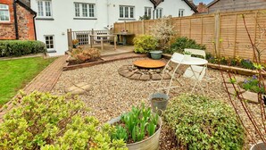 A well-maintained garden with a patio area, a wooden fence, and a variety of plants. - Stunning  villa for 6 guests with WIFI (Minehead)
