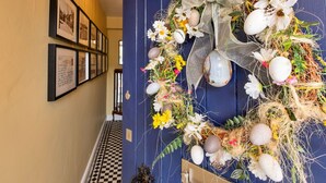A blue door adorned with a decorative wreath featuring flowers, eggs, and a bow. - Stunning  villa for 6 guests with WIFI (Minehead)