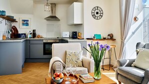 Una sala moderna con sofá, mesa de centro y vistas a la cocina.