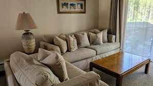 A living room with a sofa, a wooden coffee table, and a lamp.