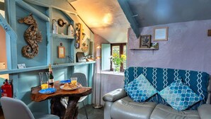 Un salon chaleureux avec une table à manger en bois, un canapé en cuir et un coussin bleu à motifs.