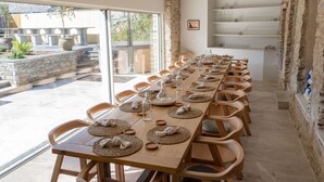 A long wooden table set for dining with woven placemats and glassware, surrounded by wooden chairs. - Beautiful  villa for 19 people with hot tub, WIFI, TV, terrace and pets allowed (Newquay)