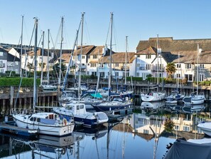 A marina with multiple boats docked, surrounded by residential buildings with thatched roofs. - Beautiful apartment for 4 people with WIFI (Falmouth)