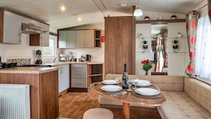 A compact kitchen with a central island, a dining area with a round table, and a cozy seating area. - Beautiful  villa for 6 people with pool, WIFI, terrace and pets allowed (Ruan Major)