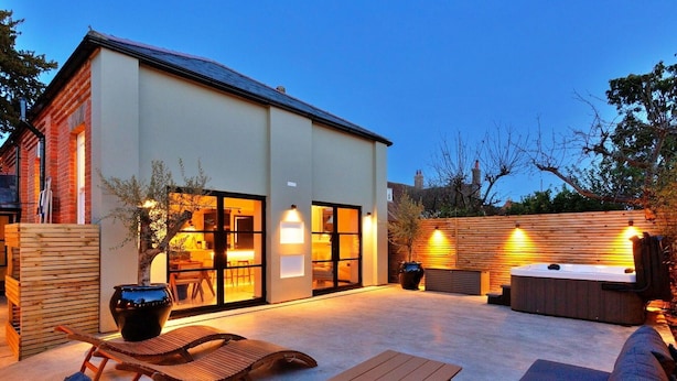 A modern outdoor patio with a hot tub, seating, and a wooden fence. - Stunning  villa for 6 people with WIFI and pets allowed (Stone)