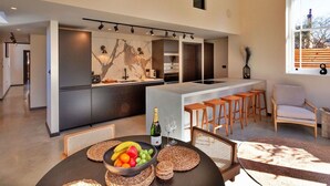 A modern kitchen with a marble backsplash, a dining area with a round table, and a large window with a view. - Stunning  villa for 6 people with WIFI and pets allowed (Stone)