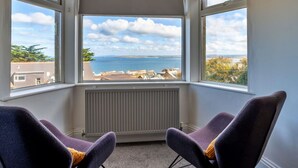 Una habitación con vista al mar, dos sillas y un radiador.