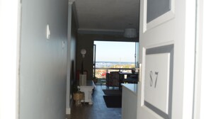 En hall som leder ut till en balkong med utsikt över havet.