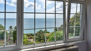 Una habitación con un ventanal grande que da a vistas de la costa.