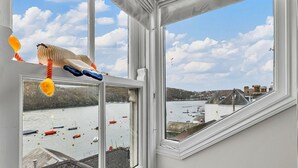 A view from a window overlooking a harbor with boats and buildings. - Stunning  villa for 6 guests with WIFI (Fowey)