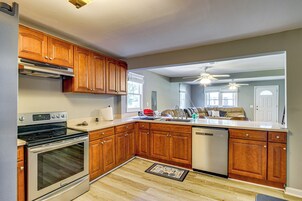 A modern kitchen with wooden cabinets, stainless steel appliances, and a large island.