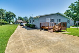 A single-story house with a front porch, a driveway, and a lawn.