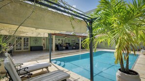 A pool area with lounge chairs, a covered seating area, and a potted plant. - 16 Mi to Fort Lauderdale: Florida Escape w/ Pool! (Plantation)