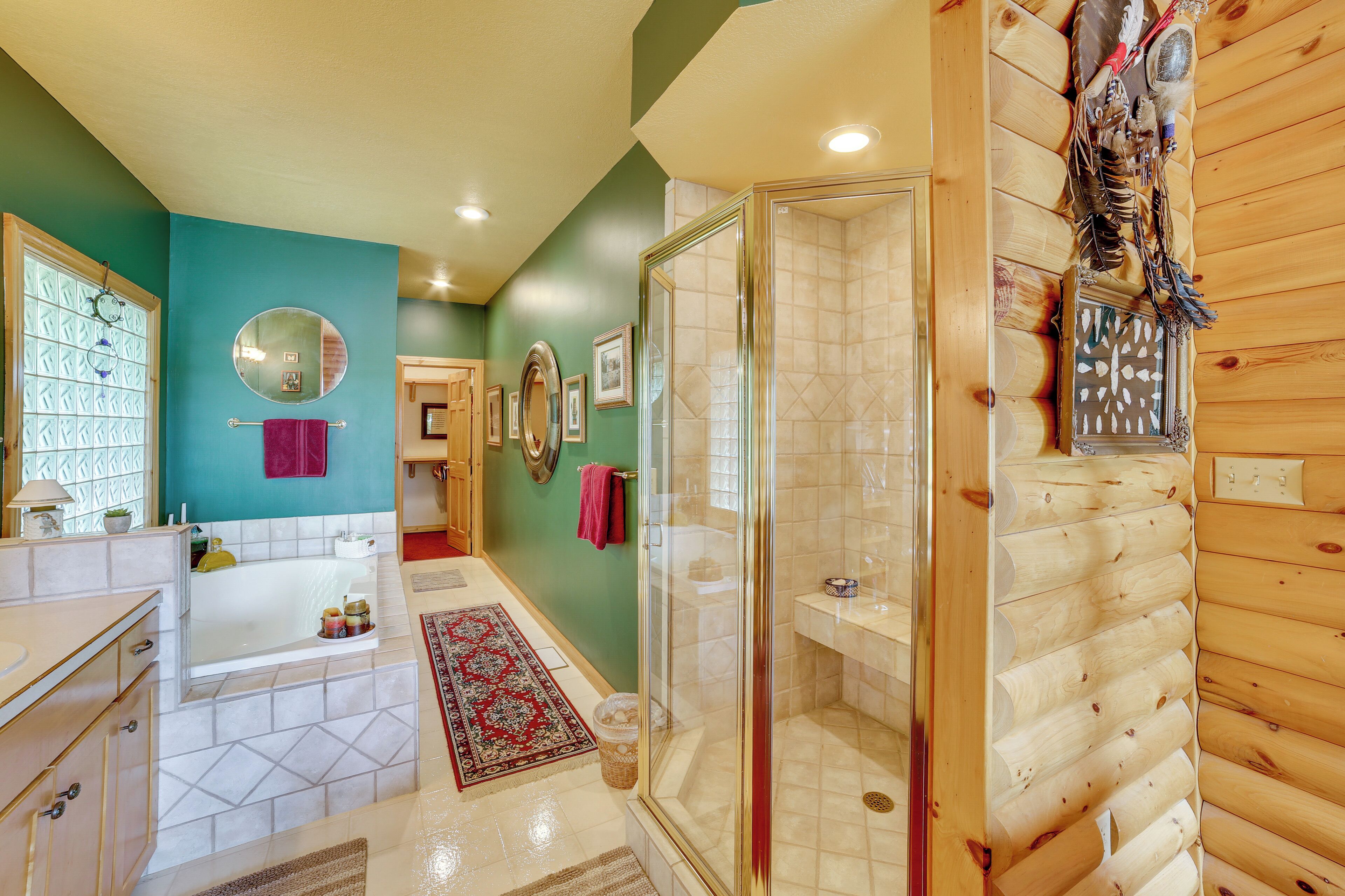 A bathroom with a glass shower enclosure, a bathtub, and a vanity with a mirror.