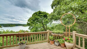 A wooden deck with potted plants and a circular metal structure. - Decks & Views: Spacious Cabin Near Table Rock Lake (Shell Knob)