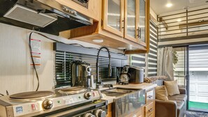 A compact kitchen with a stove, sink, and cabinets. - 10 Mi to Leesylvania & River: Sleek Mobile Home (Woodbridge)