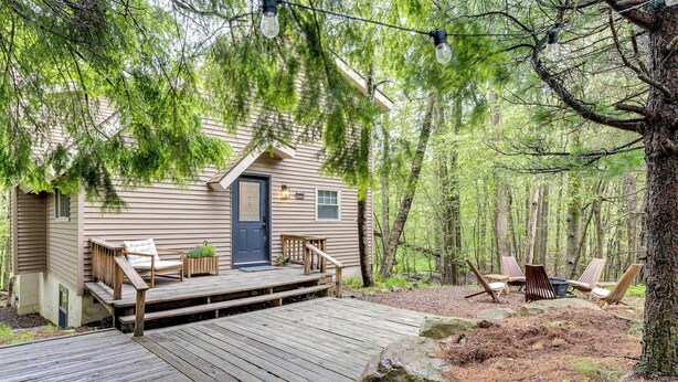 A cabin with a wooden deck, outdoor seating, and a door with a small porch. - Lake Access at Family-friendly Home in Tobyhanna (Tobyhanna)