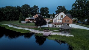 A large house with a well-maintained lawn and a pond in the foreground. - Pool, Lake & Patio: Sweeping De Soto Estate (De Soto)