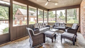 A covered patio area with wicker furniture, large windows, and a ceiling fan. - Pool, Lake & Patio: Sweeping De Soto Estate (De Soto)