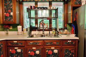 A kitchen with wooden cabinets, a stainless steel sink, and a window with a view of greenery. - Private 5-acre Lake: Pet-friendly Grove City Home (Grove City)