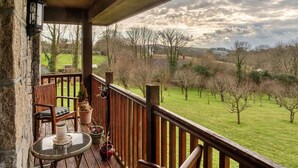 A wooden deck with a table and chairs, overlooking a grassy landscape with trees and hills. - Beautiful  villa for 2 people with WIFI (Leedstown)