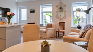 A modern living room with a round table, two sofas, a coffee table, and a TV in the background. - Beautiful  villa for 6 guests with WIFI and terrace (Saltash)