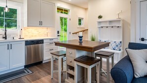 A modern kitchen with white cabinetry, a wooden island, and a built-in bench. - Canandaigua | CMAC | Fire Pit | Hot Tub | Sauna (Canandaigua)