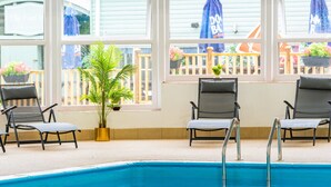 Ett poolområde med två solstolar och en krukväxt.