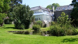 A house with a pond, surrounded by greenery and trees. - Wonderful  villa for 14 guests with WIFI and pets allowed (Dartmouth)