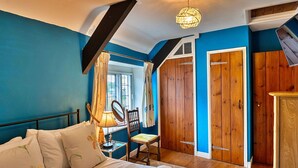 A bedroom with a bed, a chair, a desk with a lamp, a mirror, and wooden wardrobes. - Stunning  villa for 4 people with WIFI, terrace and pets allowed (Minehead)