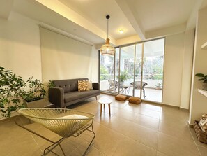 A spacious living area with a sofa, a wicker chair, and a balcony with a hammock. - Apartment for 6 guests in Sabanilla, just a few steps from the ocean (Sabanilla)
