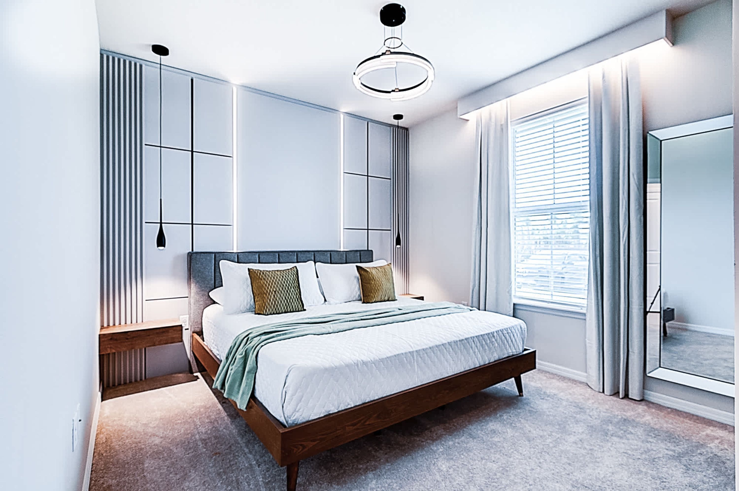 A modern bedroom with a large bed, built-in wardrobe, and a large window with curtains.