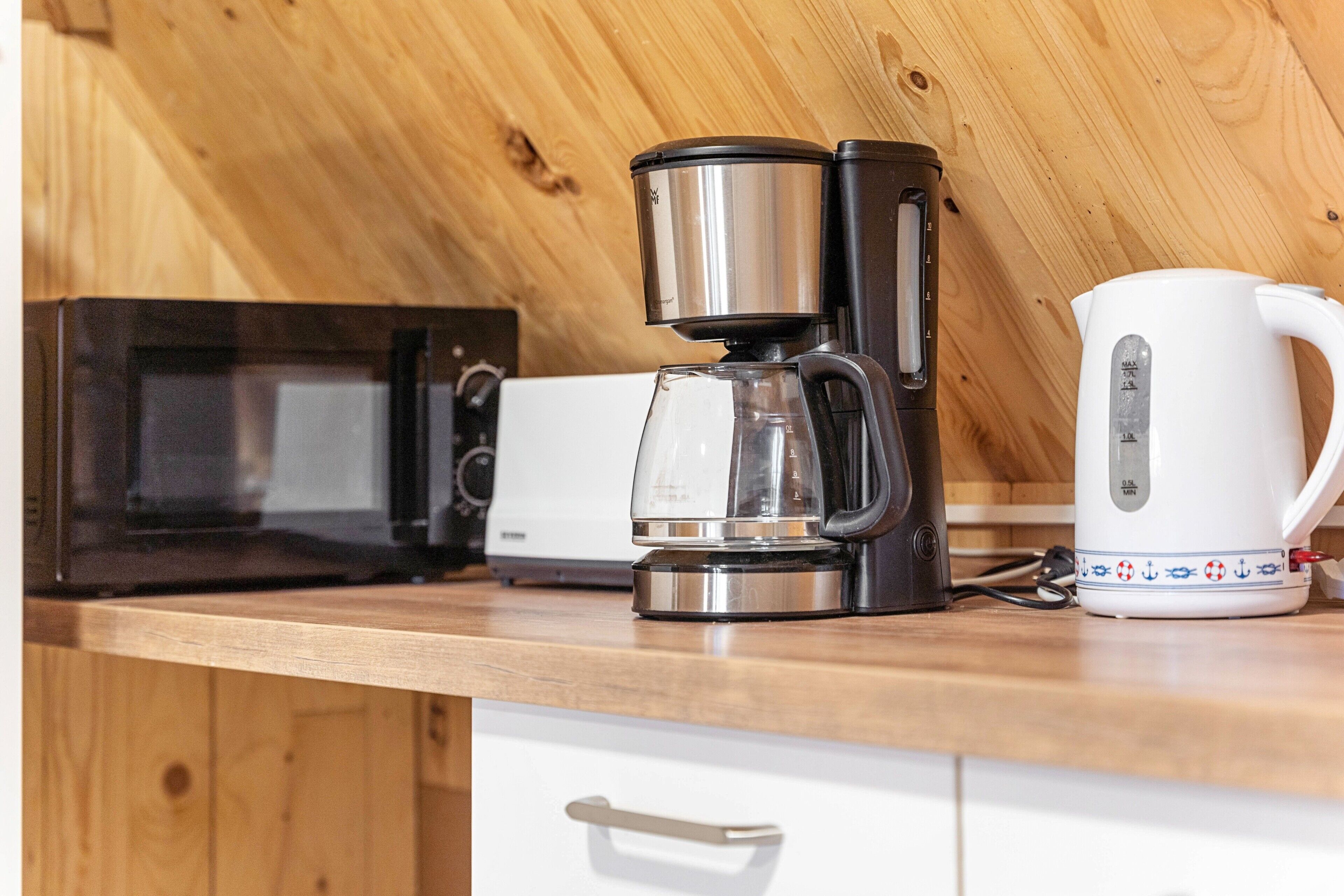 Eine Küche mit Kaffeemaschine, Wasserkocher und Mikrowelle.