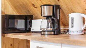 Eine Küche mit Kaffeemaschine, Wasserkocher und Mikrowelle.