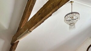 A rustic room with exposed wooden beams, a copper bathtub, a chandelier, and a fireplace. - Stunning  villa for 6 people with WIFI and pets allowed (Cawsand)