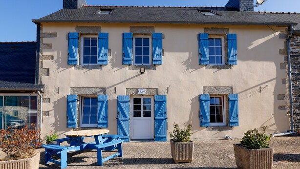 A building with a stone facade, multiple windows with shutters, a door, and a satellite dish. - Bed and Breakfast 'Breizh' with Private Terrace, Shared Garden and Wi-Fi (CAST)