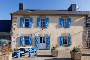 A building with a stone facade, multiple windows with shutters, a door, and a satellite dish. - Bed and Breakfast 'Breizh' with Private Terrace, Shared Garden and Wi-Fi (CAST)
