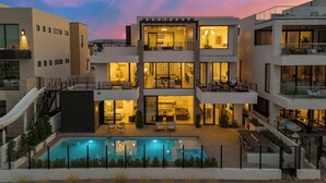 Un immeuble moderne à plusieurs étages, doté d’une piscine, de balcons et d’un télésiège.