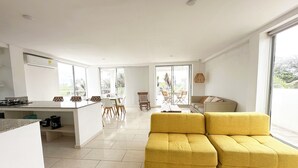 A modern living space with a kitchen, dining area, and a yellow sofa. - Apartment for 8 Guests in Sabanilla a Few Steps from the Sea (Sabanilla)