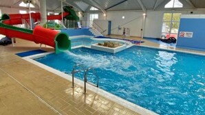 An indoor swimming pool with a slide, a shallow play area, and a lifeguard stand. - Wonderful  villa for 6 people with WIFI, pool, TV and terrace (Newtown)